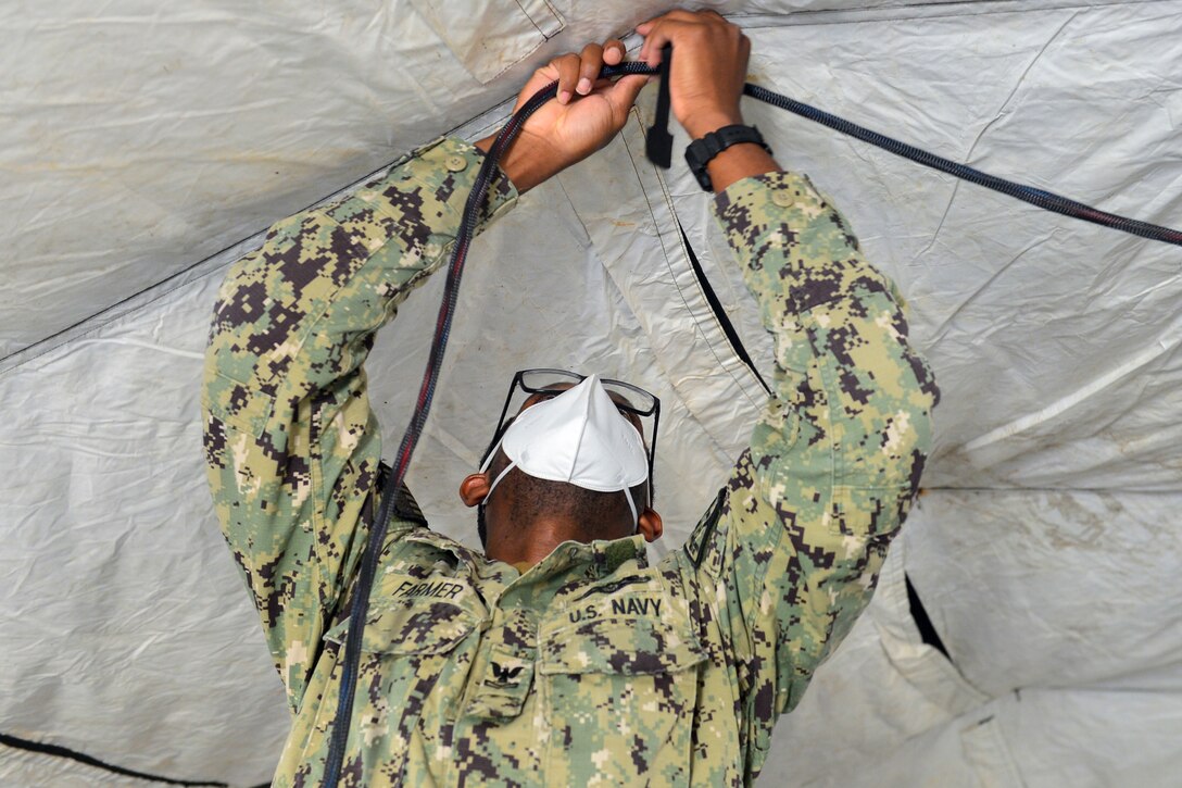 A sailor holds a cable.