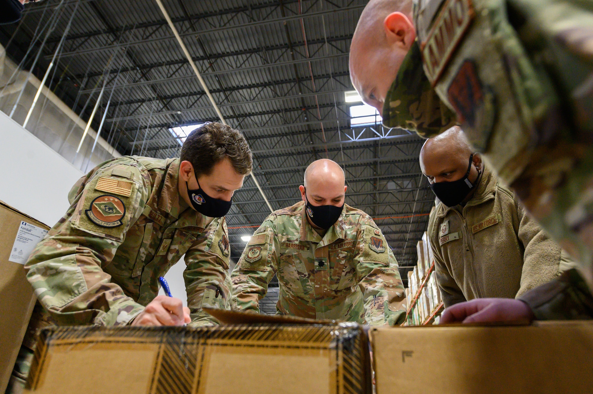 Airmen from the Maryland Air National Guard review distribution plans before transporting cases of Remdesivir, one of the therapeutic treatments believed to be effective against the omicron COVID-19 variant, on Jan. 14, 2022, at a Strategic National Stockpile warehouse in Maryland. At the direction of Governor Larry Hogan, up to 1,000 MDNG members were activated to assist state and local health officials with their response to rising COVID-19 cases and hospitalizations to include the distribution of treatment medicine and personal protective equipment. (U.S. Air National Guard photo by Staff Sgt. Sarah M. McClanahan)