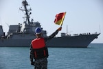 BERENICE, Egypt (Feb. 5, 2022) An Egyptian Navy sailor signals to guided-missile destroyer USS Jason Dunham (DDG 109) in Berenice, Egypt, Feb. 5, during International Maritime Exercise/Cutlass Express 2022. IMX/Cutlass Express 2022 is the largest multinational training event in the Middle East, involving more than 60 nations and international organizations committed to enhancing partnerships and interoperability to strengthen maritime security and stability. (U.S. Army photo by Sgt. David Resnick)