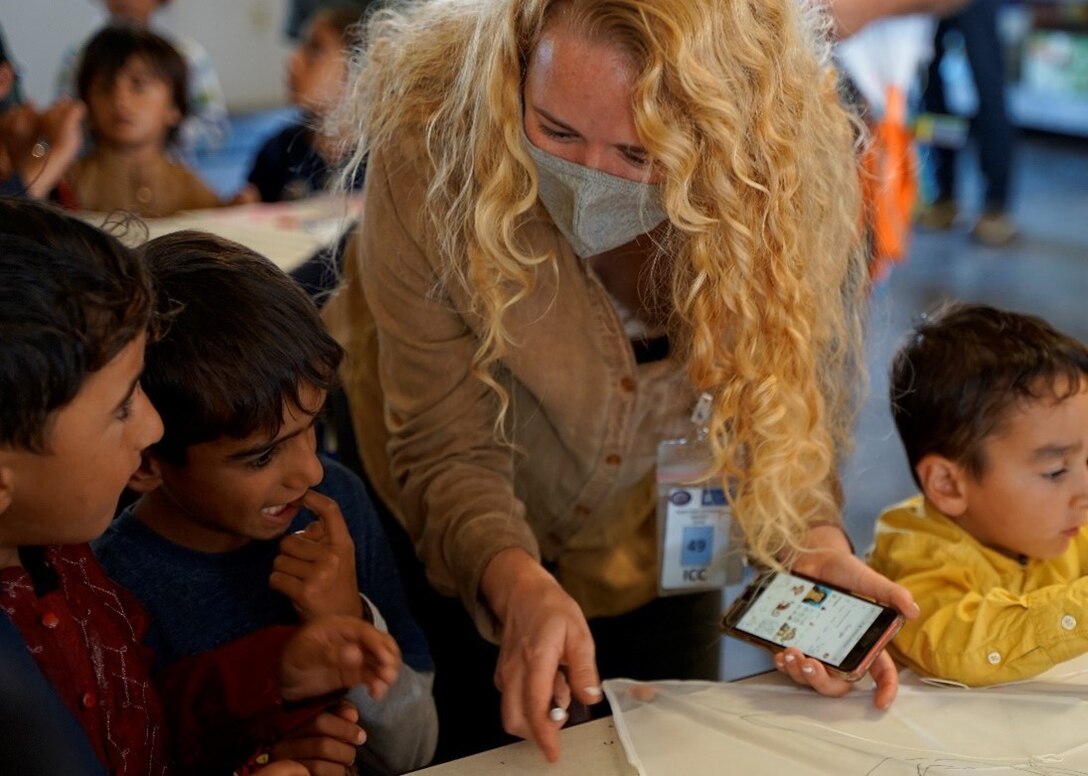 Corina Stahl, an Activity Lead for the United States Conference of Catholic Bishops, coordinates “Kite Day” for Afghan children at Camp Atterbury, Ind., Oct. 21, 2021, as part of Operation Allies Welcome. Children decorated and flew kites alongside Soldiers and their inter-agency partners. The Department of Defense, through U.S. Northern Command, and in support of the Department of Homeland Security, is providing transportation, temporary housing, medical screening, and general support for at least 50,000 Afghan evacuees at suitable facilities in permanent or temporary structures as quickly as possible. (U.S. Army photo by Sgt. Trinity Carter / 14th Public Affairs Detachment)