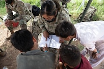 Pfc. Eulalia Andres, center, assigned to 1st Battalion, 37th Armored Regiment, and member of the female engagement team, learns how to speak Pashto and Dari from Afghan evacuees, Sept. 1, 2021, at Fort Bliss' Doña Ana Complex in New Mexico. The Department of Defense, through U.S. Northern Command, and in support of the Department of Homeland Security, is providing transportation, temporary housing, medical screening, and general support for at least 50,000 Afghan evacuees at suitable facilities, in permanent or temporary structures, as quickly as possible. This initiative provides Afghan personnel essential support at secure locations outside Afghanistan. (U.S. Army photo by Sgt. Quintin Gee, 24th Theater Public Affairs Support Element)