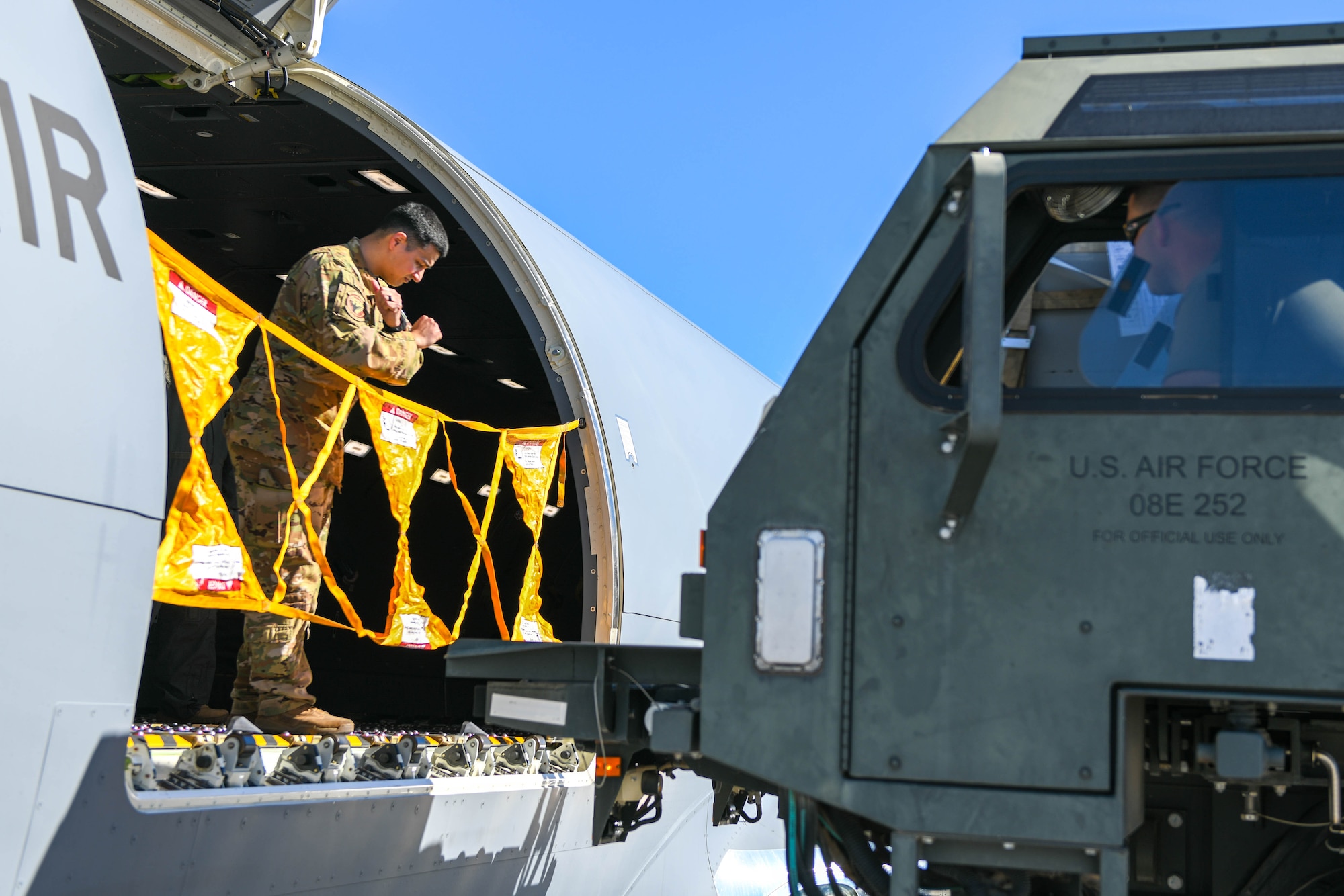 U.S. Air Force Tech. Sgt. Joshua Granados, 56th Air Refueling Squadron (ARS) loadmaster, directs a 60K aircraft cargo loader/transporter on Luke Air Force Base (AFB), Arizona, Jan. 27, 2022. The 56th ARS assisted the 56th Operations Group during Silver Paladin, moving both cargo and passengers to Tyndall AFB. (U.S. Air Force photo by Airman 1st Class Trenton Jancze)