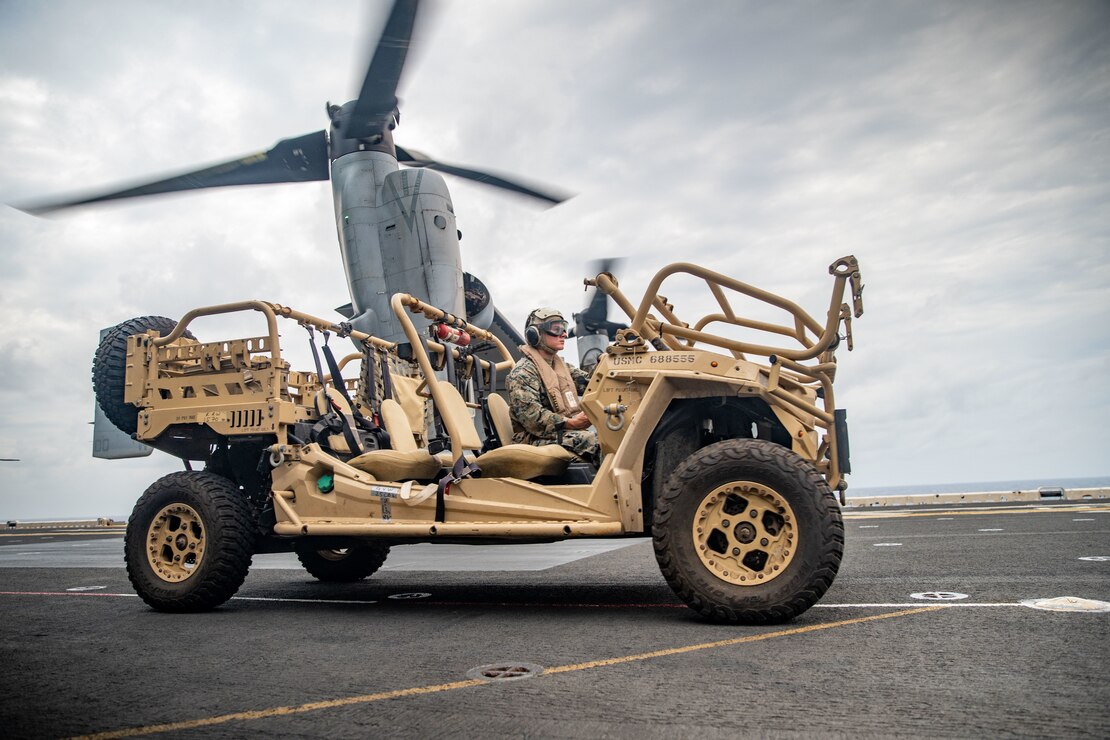 PHILIPPINE SEA (Feb. 3, 2022) A U.S. Marine assigned to the All-Domain Reconnaissance Detachment, 11th Marine Expeditionary Unit (MEU), prepares to load a Polaris MRZR light tactical all-terrain vehicle onto an MV-22B Osprey attached to Marine Medium Tiltrotor Squadron (VMM) 165 (Reinforced), 11th MEU, on the flight deck of Wasp-class amphibious assault ship USS Essex (LHD 2) in support of Exercise Noble Fusion, Feb. 3, 2022. . As a forward deployed unit capable of conducting amphibious operations, crisis response, and limited contingency operations, the 11th MEU regularly conducts training to be able to operate in contested areas to create strategic advantage while building lethality and integrated deterrence. Noble Fusion demonstrates that Navy and Marine Corps forward-deployed, stand-in naval expeditionary forces can operate as a Marine Expeditionary Unit/Amphibious Ready Group team at sea, along with a carrier strike group, in order to conduct lethal sea-denial operations, seize key maritime terrain, guarantee freedom of movement, and create advantage for U.S., partner, and allied forces. (U.S. Marine Corps photo by Sgt. Jennessa Davey)