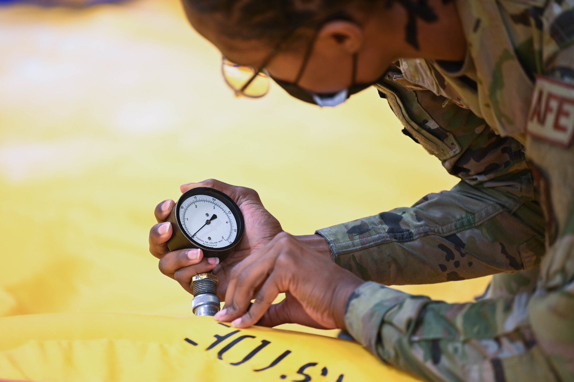 Airman 1st Class Miya Lyons, 15th Operations Support Squadron aircrew flight equipment apprentice, checks the air pressure in a 46-man life raft during a functional check at Joint Base Pearl Harbor-Hickam, Hawaii, Feb. 1, 2022. AFE regularly tests, inspects and prepares safety equipment located on the aircraft to ensure safety of the aircrew and passengers. (U.S. Air Force photo by Staff Sgt. Alan Ricker)