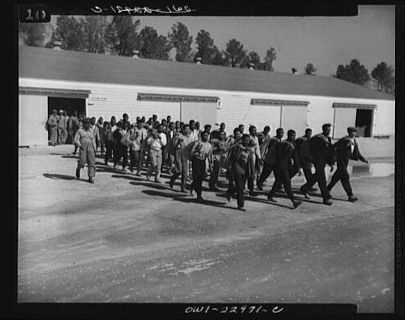 Marines walk out of a warehouse building.