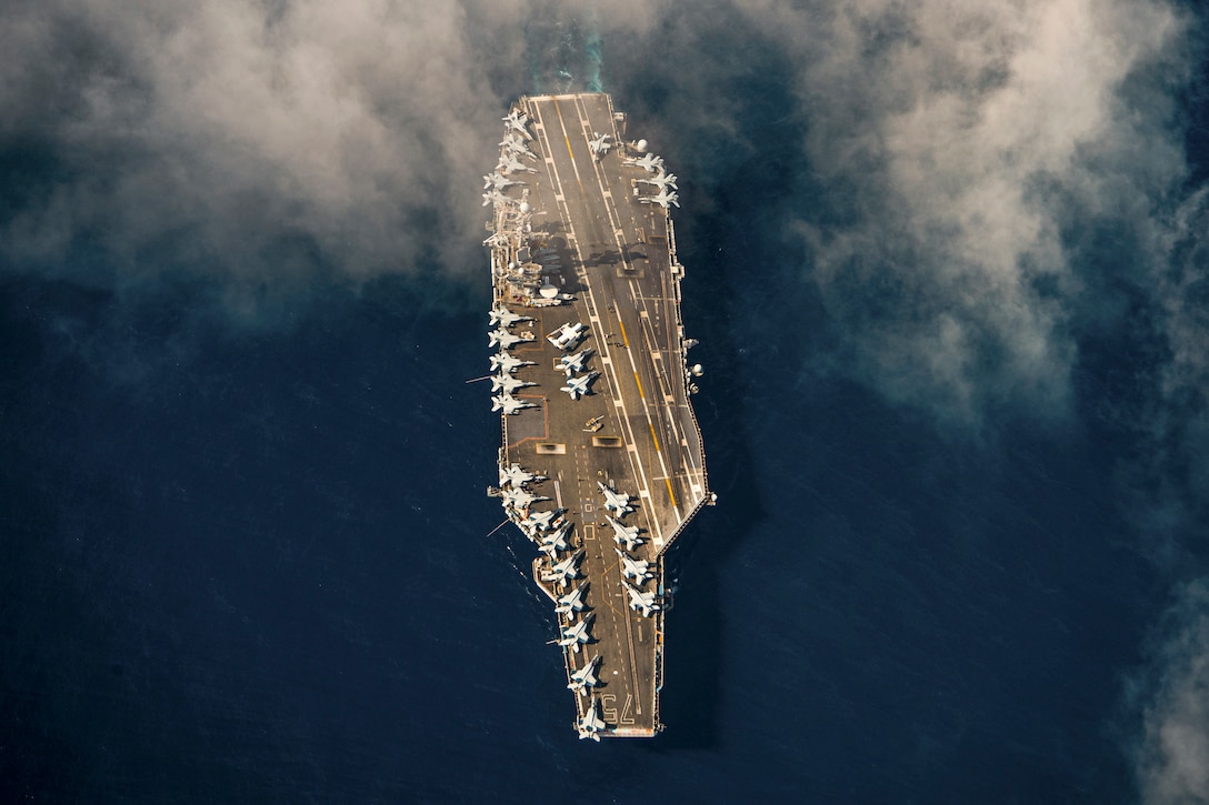 A ship moves through a body of water as seen from above.