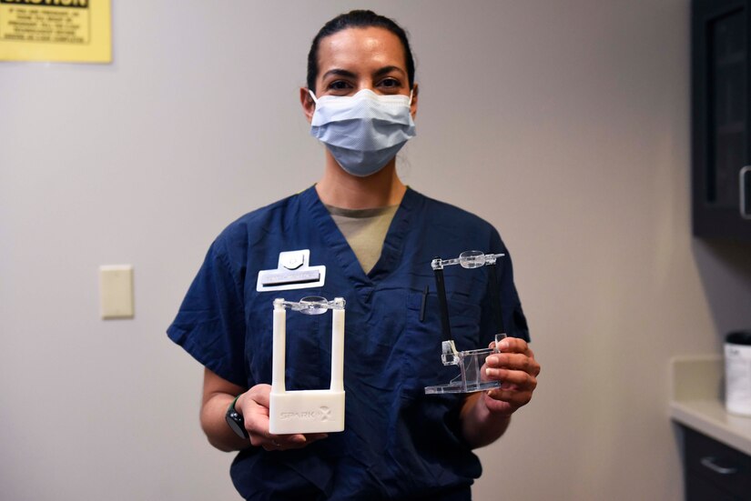 U.S. Air Force Tech Sgt. Ana Gomez-Martinez, 316th Wing Dental Squadron oral prophylaxis assistant, holds two different 3-D modeled structures, Joint Base Andrews, Md., Feb. 3, 2022.
