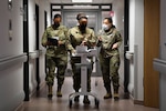 Airmen assigned to the 86th Medical Group discuss training for medics regarding the new ElectroCardiogram (EKG) at Ramstein Air Base, Germany, Feb. 3, 2022. An EKG takes a snapshot of a patient's cardiac rhythms, which helps medical providers diagnose and treat dysrhythmia. (U.S. Air Force photo by Airman 1st Class Jared Lovett)