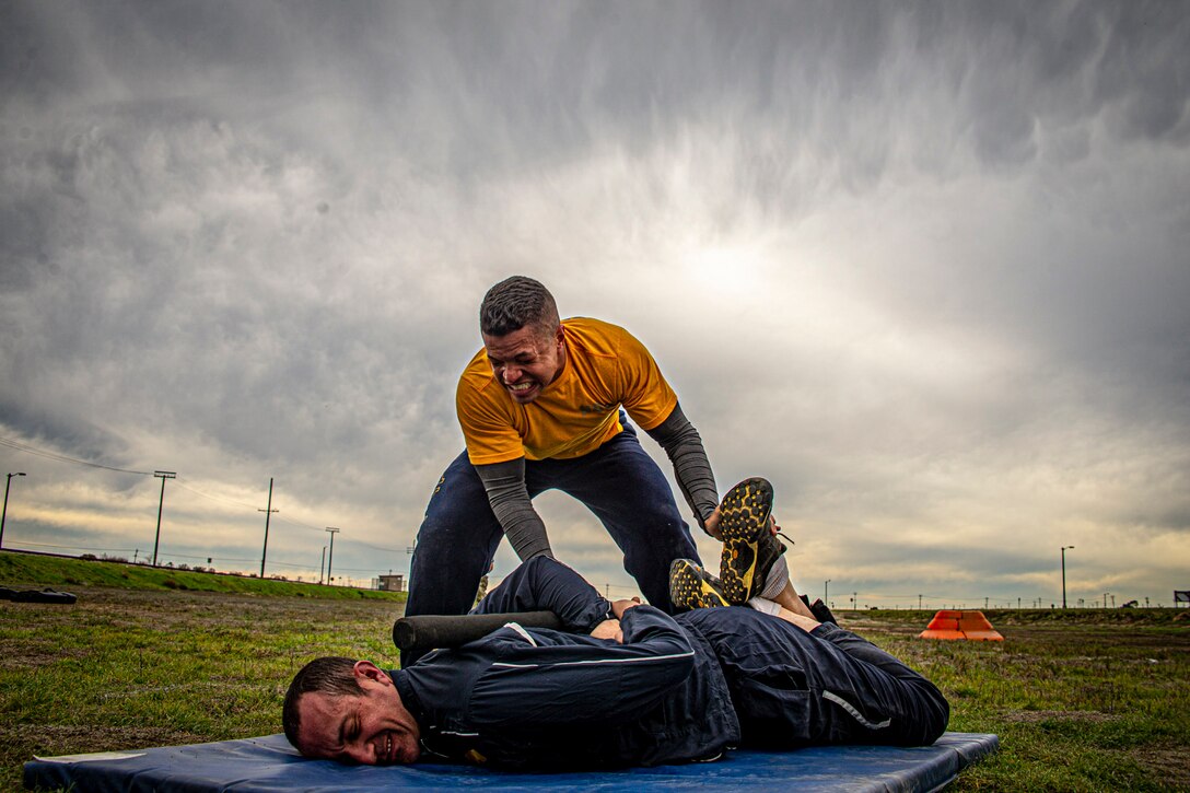 A sailor performs a takedown on another sailor.