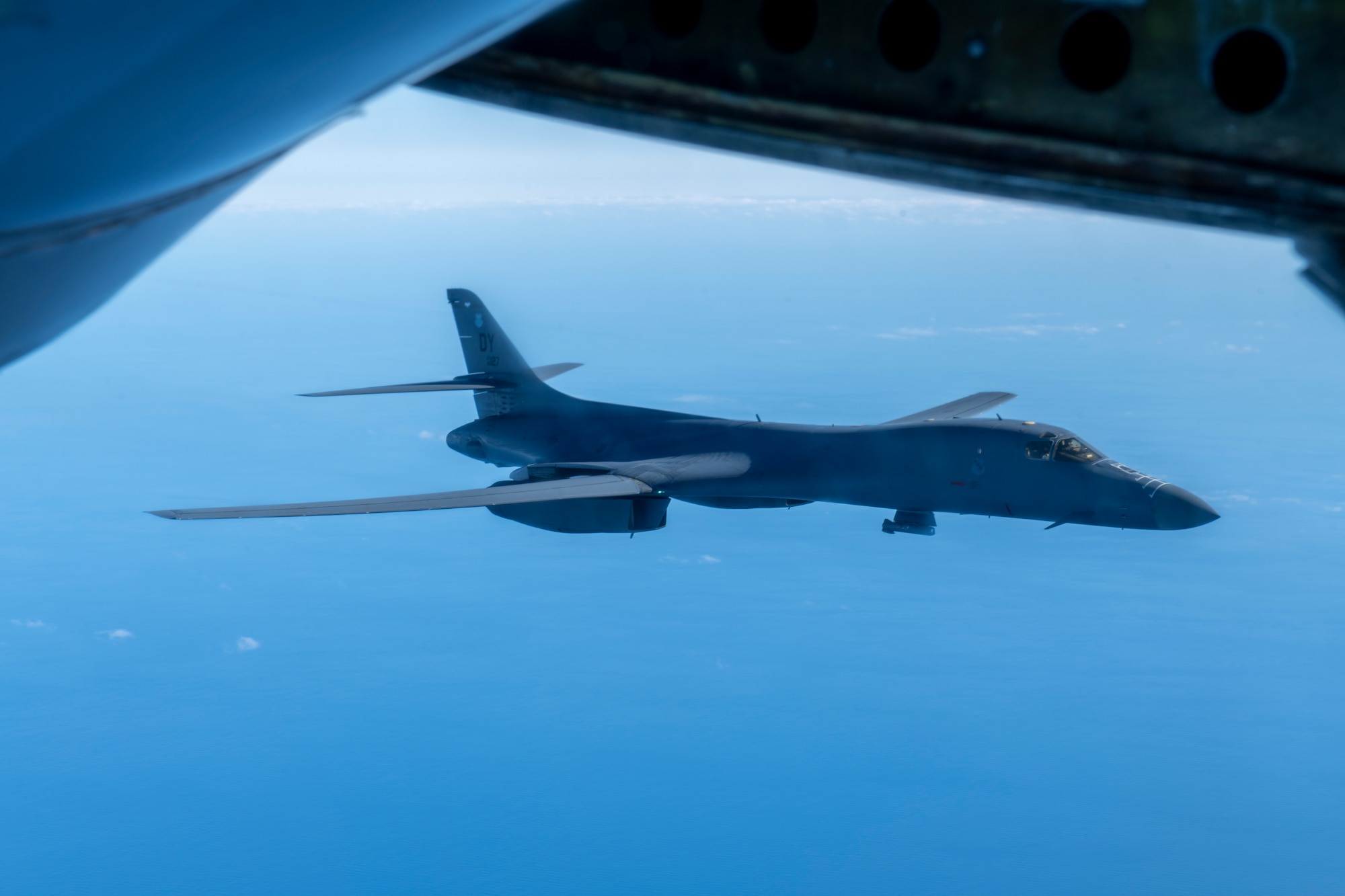 A B-1 Lancer from the 7th Bomb Wing departs after receiving fuel over the Pacific Ocean during a Bomber Task Force deployment, Jan. 11, 2022. A BTF deployment of U.S. Air Force B-1 Lancers, Airmen and support equipment from the 7th Bomb Wing, Dyess Air Force Base, Texas, coordinated with the 909th Air Refueling Squadron to support Pacific Air Forces’ training efforts with allies, partners, and joint forces and strategic deterrence missions to reinforce the rules-based international order in the Indo-Pacific region. (U.S. Air Force photo by Airman 1st Class Moses Taylor)