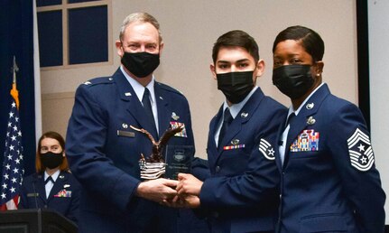 Col. Terry McClain, 433rd Airlift Wing commander, and Chief Master Sgt. Takesha Williams, 433rd AW command chief, present the Airman of the Year award to Staff Sgt. Christian Alejos, 433rd Aircraft Maintenance Squadron, at the wing’s annual awards ceremony Feb. 5, 2022, at Joint Base San Antonio-Lackland, Texas. Alejos was recently promoted to staff sergeant. (U.S. Air Force photo by Staff Sgt. Monet Villacorte)