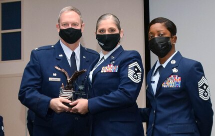 Col. Terry McClain, 433rd Airlift Wing commander, and Chief Master Sgt. Takesha Williams, 433rd AW command chief, present the First Sergeant of the Year award to Senior Master Sgt. Tania Mcguire, 433rd Civil Engineer Squadron, at the wing’s annual awards ceremony Feb. 5, 2022, at Joint Base San Antonio-Lackland, Texas. (U.S. Air Force photo by Staff Sgt. Monet Villacorte)