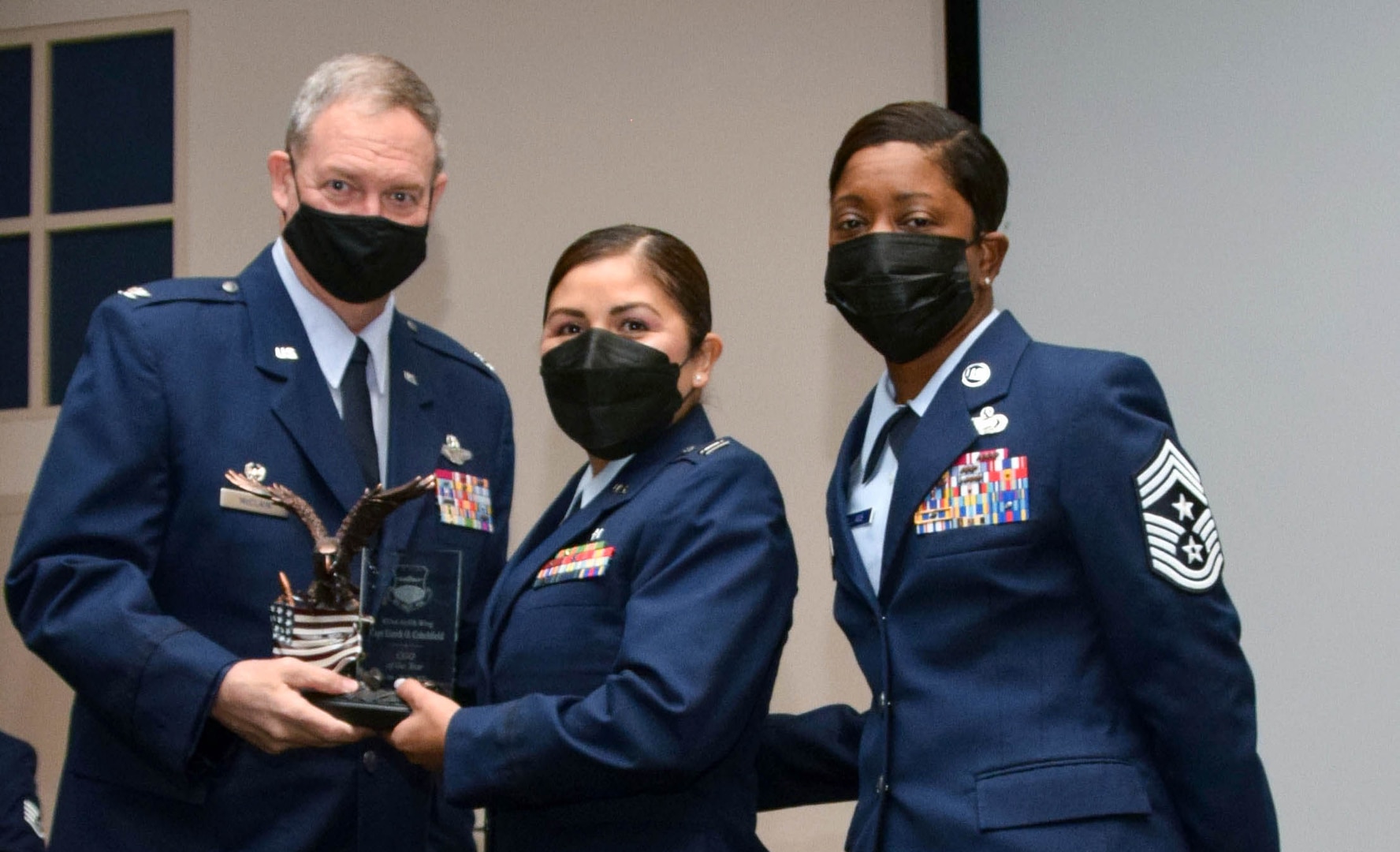 Col. Terry McClain, 433rd Airlift Wing commander, and Chief Master Sgt. Takesha Williams, 433rd AW command chief, present the Company Grade Officer of the Year award to Capt. Lizeth Critchfield, 433rd Medical Squadron, at the wing’s annual awards ceremony Feb. 5, 2022, at Joint Base San Antonio-Lackland, Texas. (U.S. Air Force photo by Staff Sgt. Monet Villacorte)
