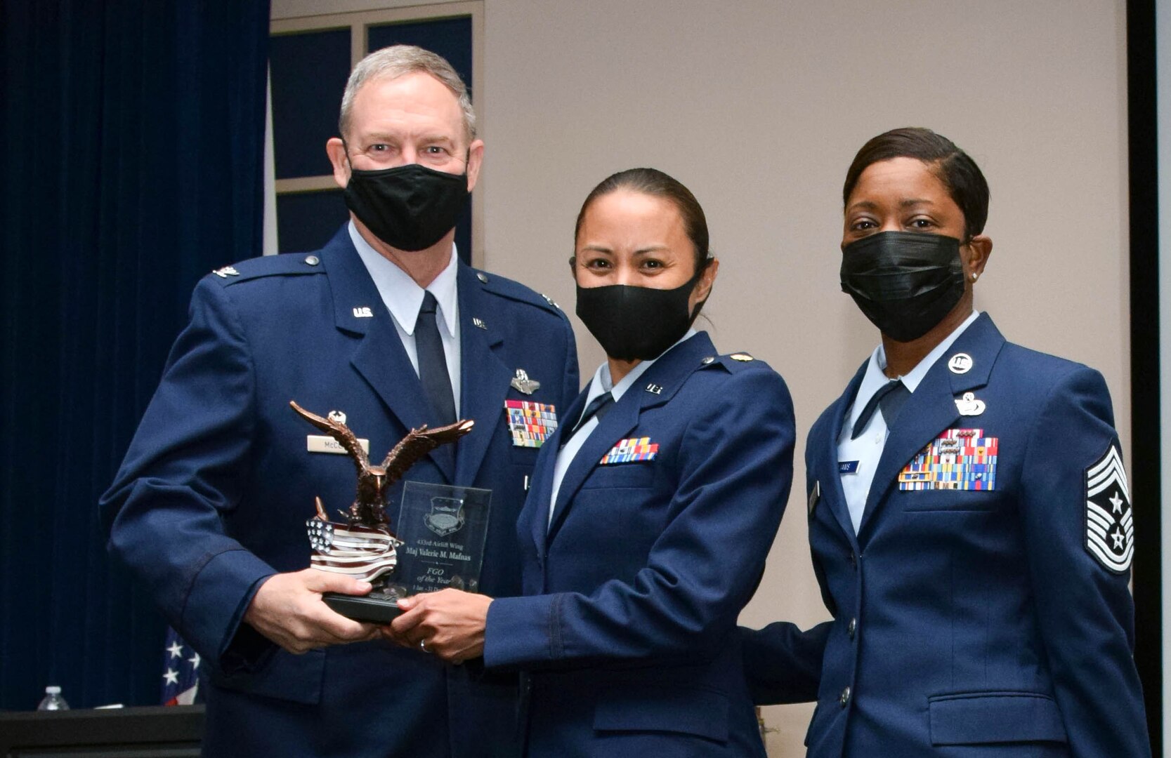 Col. Terry McClain, 433rd Airlift Wing commander, and Chief Master Sgt. Takesha Williams, 433rd AW command chief, present the Field Grade Officer of the Year award to Maj. Valerie Mafnas, 26th Aerial Port Squadron, at the wing’s annual awards ceremony Feb. 5, 2022, at Joint Base San Antonio-Lackland, Texas. (U.S. Air Force photo by Staff Sgt. Monet Villacorte)