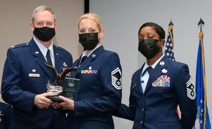 Col. Terry McClain, 433rd Airlift Wing commander, and Chief Master Sgt. Takesha Williams, 433rd AW command chief, present the Category II Civilian of the Year award to Senior Master Sgt. Lisa Green, 433rd Aerospace Medicine Squadron, at the wing’s annual awards ceremony Feb. 5, 2022, at Joint Base San Antonio-Lackland, Texas. Green works in a dual capacity as a military member and a civilian employee. (U.S. Air Force photo by Staff Sgt. Monet Villacorte)