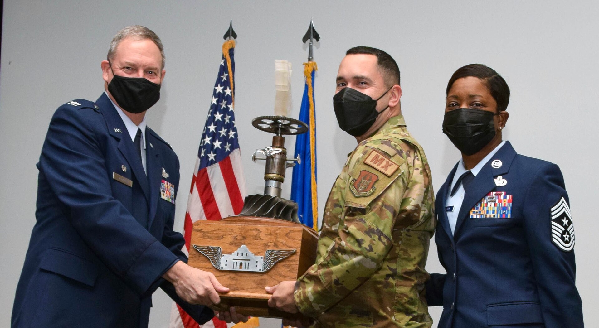 Maj. Nicholas Velazquez, 433rd Maintenance Squadron commander, accepts the Alamo Wing Combat Ready Spirit Award on behalf of the 433rd MXS from Col. Terry McClain, 433rd Airlift Wing commander, and Chief Master Sgt. Takesha Williams, 433rd AW command chief, at the wing’s annual awards ceremony Feb. 5, 2022, at Joint Base San Antonio-Lackland, Texas. (U.S. Air Force photo by Staff Sgt. Monet Villacorte)
