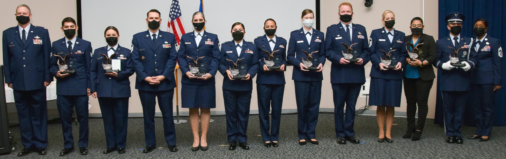 Col. Terry McClain, 433rd Airlift Wing commander, and Chief Master Sgt. Takesha Williams, 433rd AW command chief, stand with the annual wing award winners after the awards ceremony Feb. 5, 2022, at Joint Base San Antonio-Lackland, Texas. (U.S. Air Force photo by Staff Sgt. Monet Villacorte)