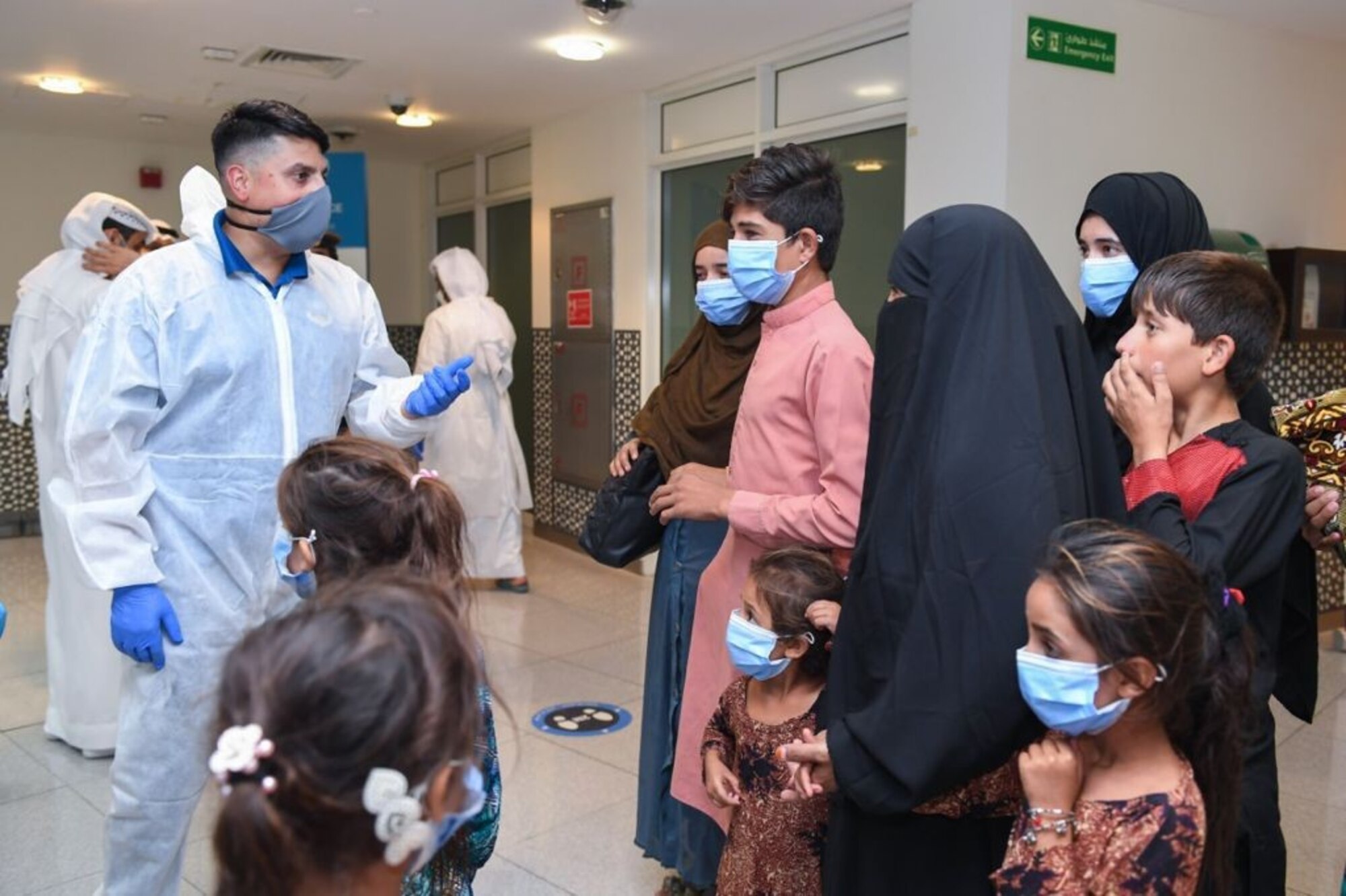 U.S. Air Force Lt. Col. Asim Khan, LEAP Scholar and director of staff, U.S. Air Forces Central Air Warfare Center, Al Dhafra Air Base, United Arab Emirates, helps transition Afghan evacuees from Abu Dhabi International Airport to the Emirati Humanitarian City during the evacuation of American citizens, special immigrant visa applicants and other at-risk individuals from Afghanistan in August 2021.