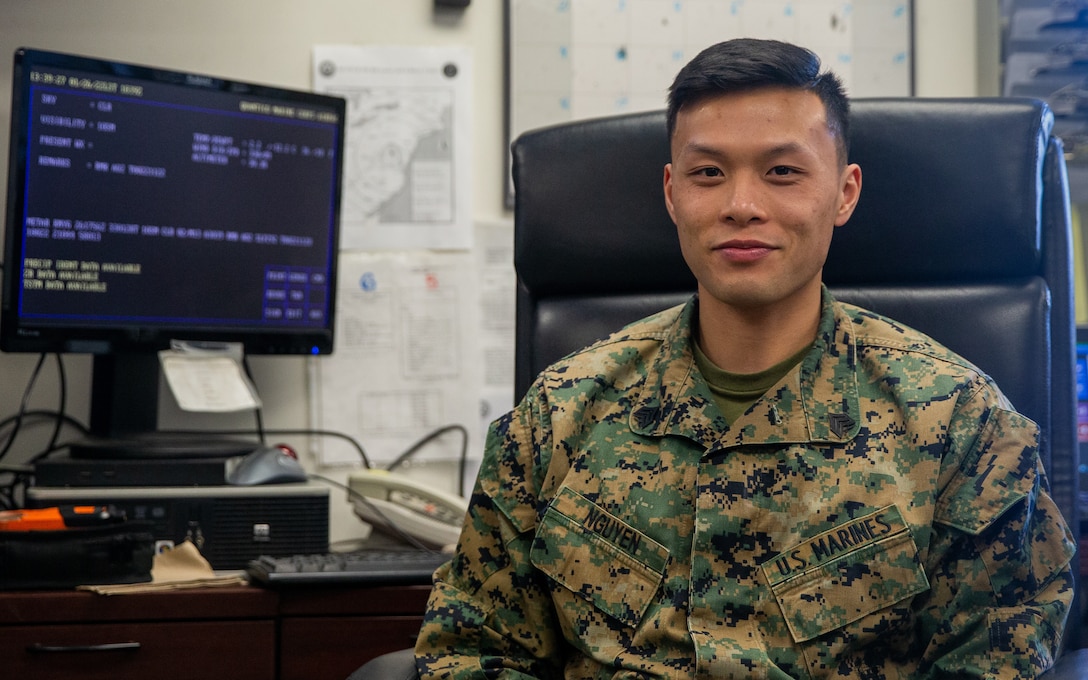 U.S. Marine Corps Sgt. Matthew Ngyuen, a meteorology and oceanography (METOC) analyst forecaster with Marine Corps Air Facilities Quantico, poses for a portrait at his desk at Marine Corps Base Quantico, Virginia, Jan. 26, 2022. METOC provides meteorological support to aircrews, pilots, training units, and the base commander by delivering up-to-date and accurate weather forecasts and conditions, promoting safe operations across the base. (US Marine Corps photo by Lance Cpl. Kayla LaMar)