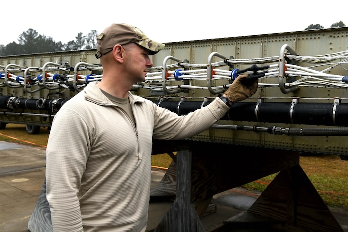 Military person inspecting wire