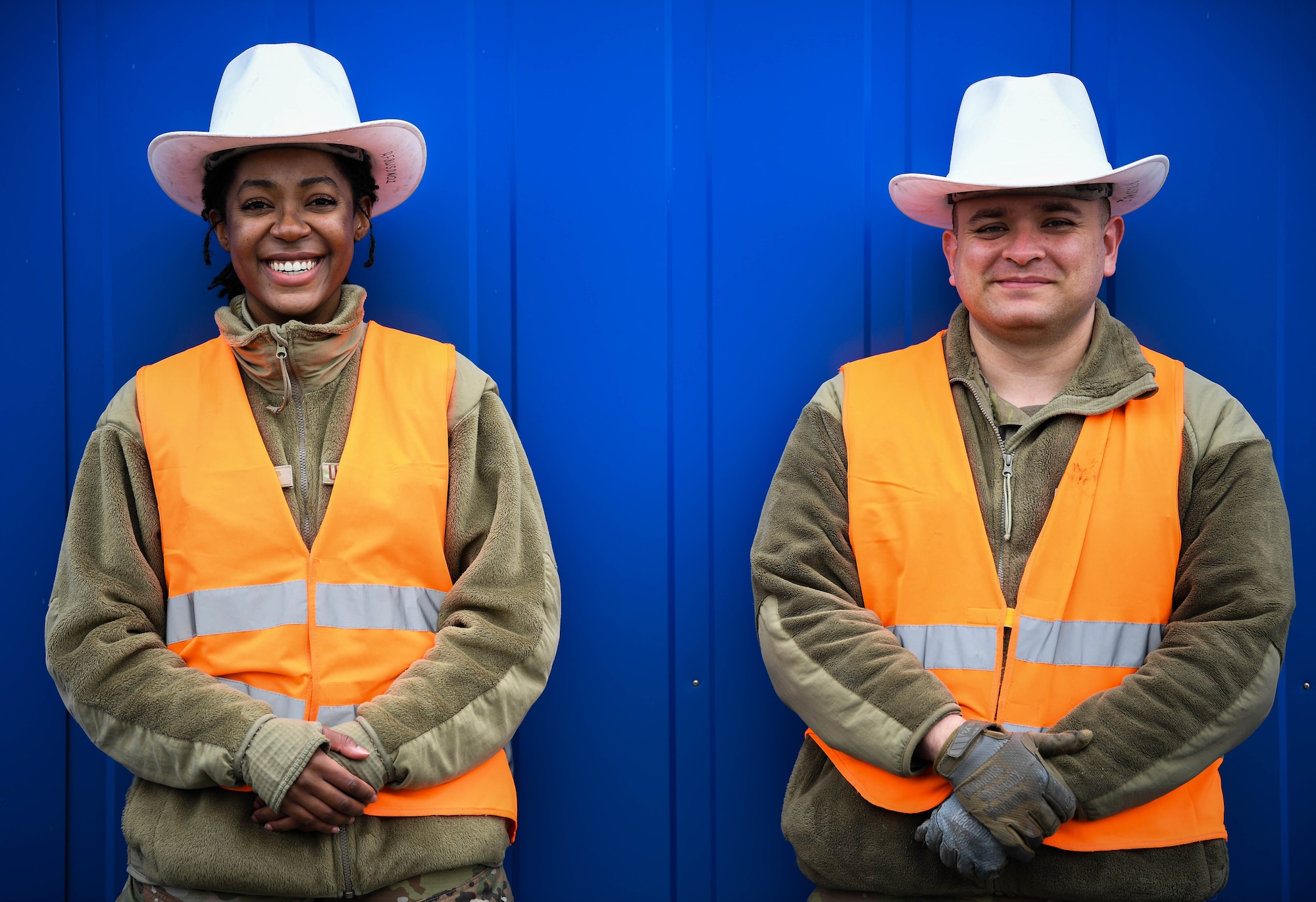 .S. Air Force Airman 1st Class Lauriell Young, left, and Senior Airman Cesar Lopez, right, 86th Munitions Squadron stockpile management crew members , prepare to spot for a forklift at Ramstein Air Base, Germany, Feb. 4, 2022. Spotters are the eyes of the Airmen who drive the 50k forklift, guiding them as they safely place munitions cargo on a semi truck. (U.S. Air Force photo by Airman 1st Class Jared Lovett)