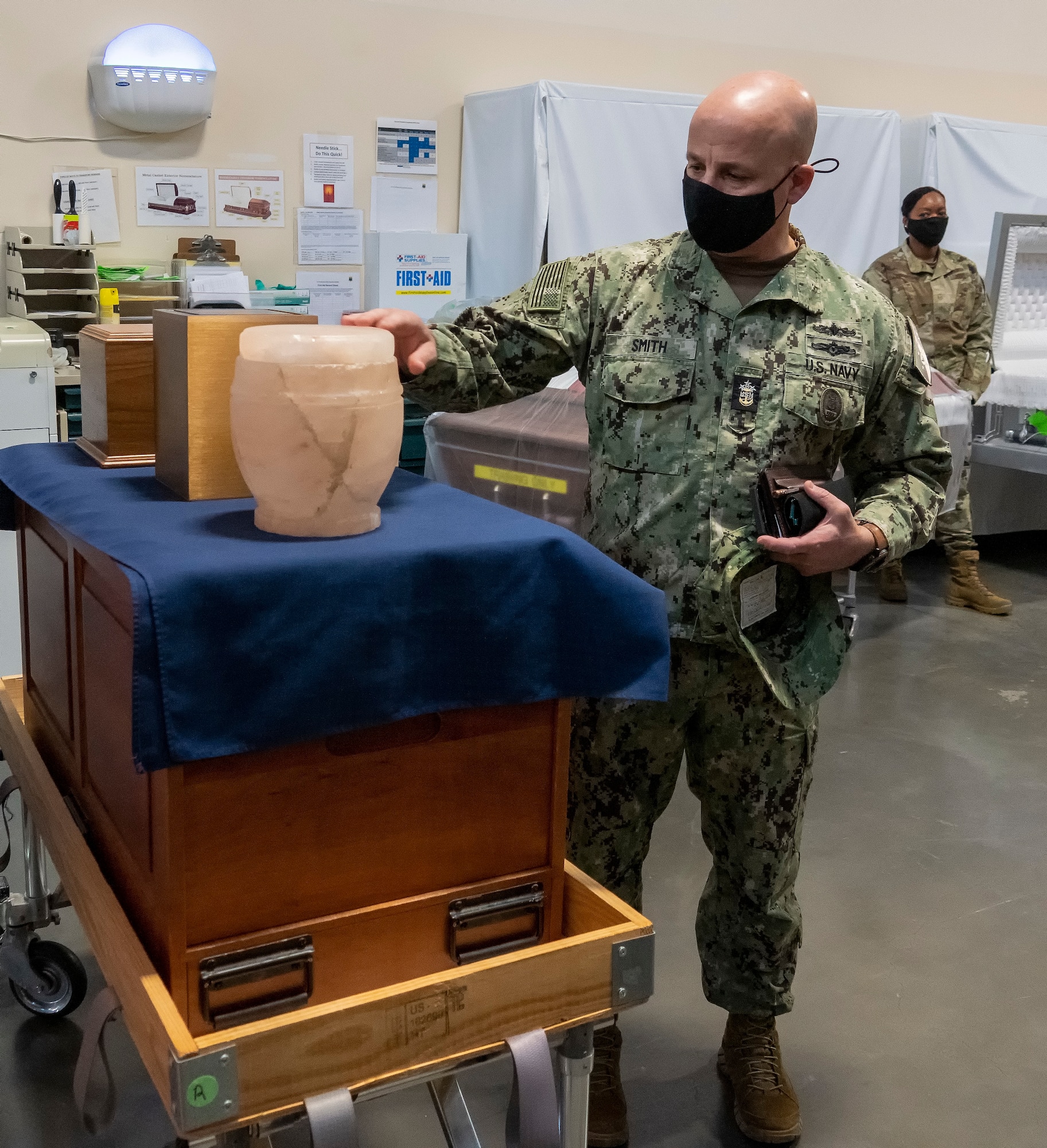 Master Chief Petty Officer of the Navy Russell Smith examines a salt urn at Air Force Mortuary Affairs Operations, Dover Air Force Base, Delaware Feb. 8, 2022. Smith and Sergeant Major of the Marine Corps Troy Black visited AFMAO to learn about the mission of providing dignity, honor and respect to the fallen and care, service and support to their families. (U.S. Air Force photo by Jason Minto)