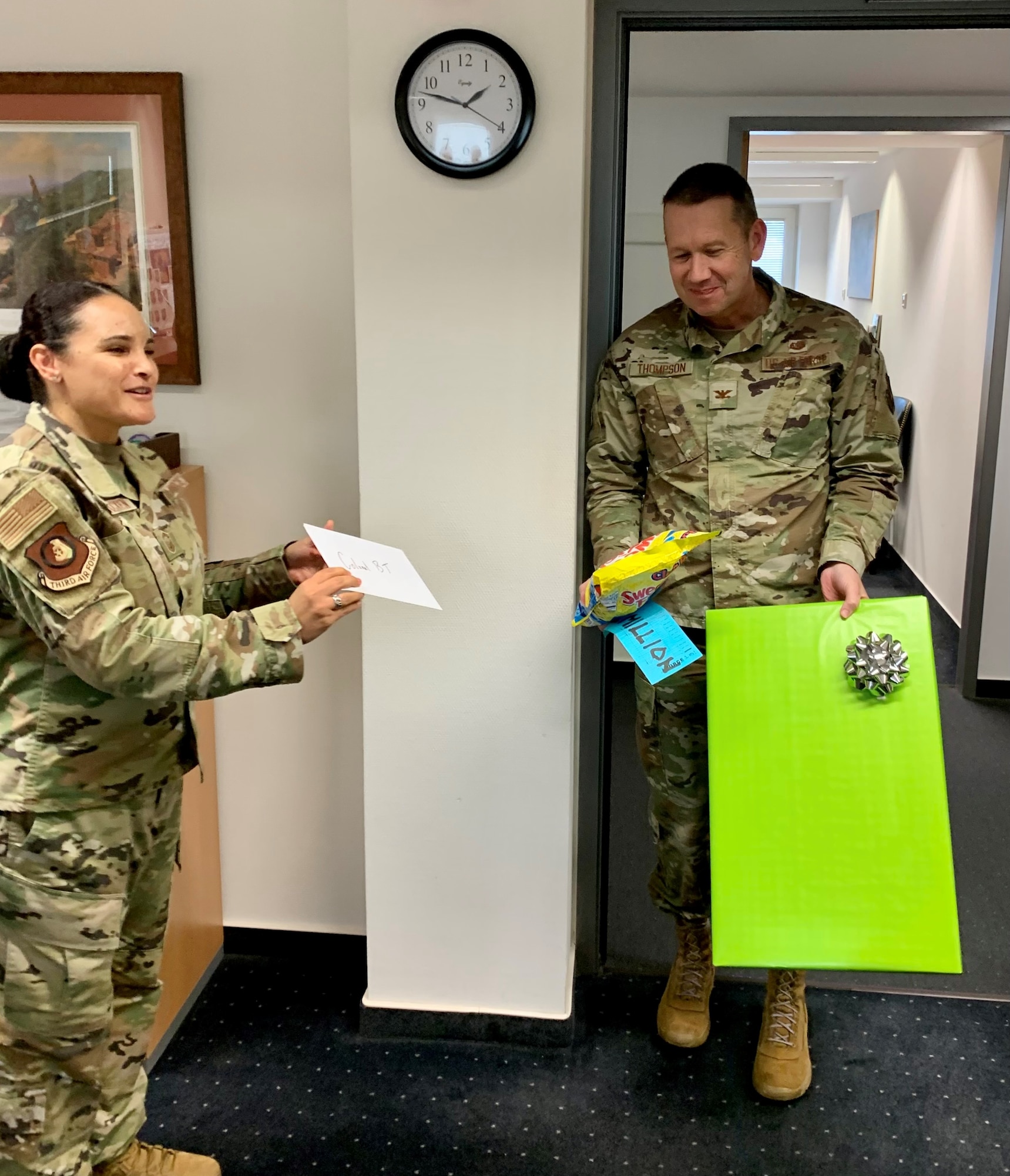 A woman hands a card to a man holding candy.