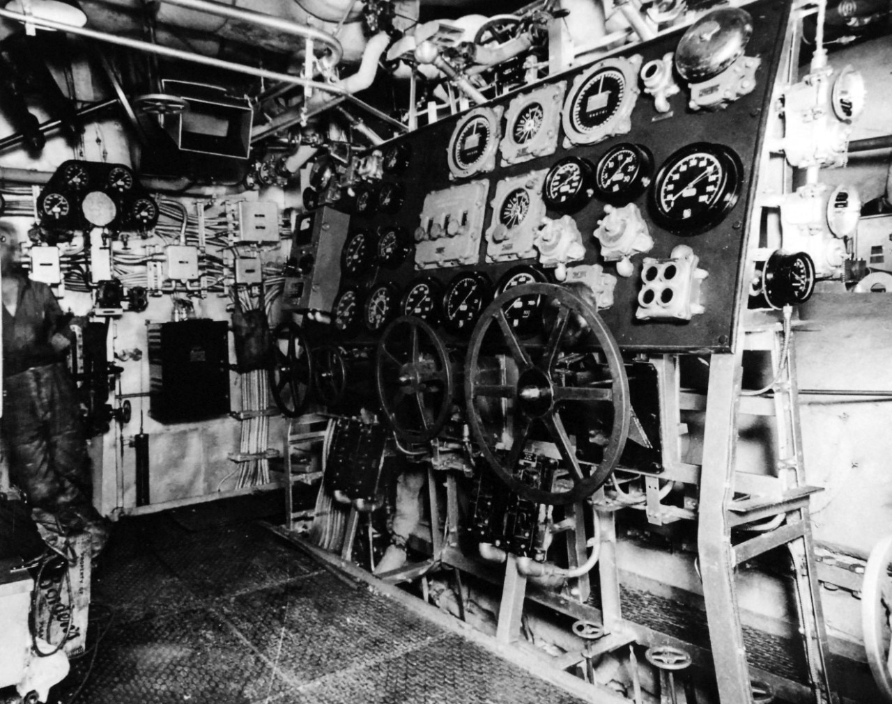 Wheels, gauges and other equipment fill a ship’s engine room.