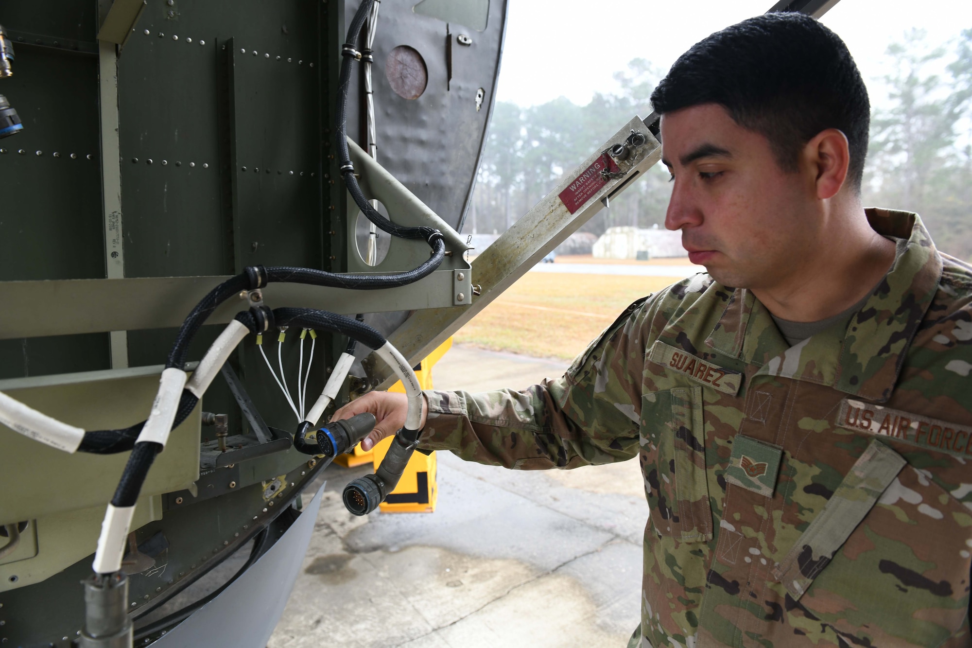 Military person inspecting a wire
