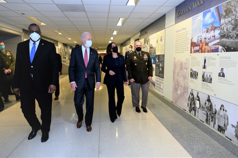 A group of people walk down a hallway.