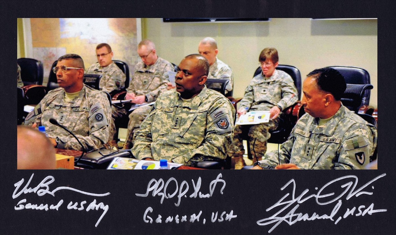 Service members sit at a desk.