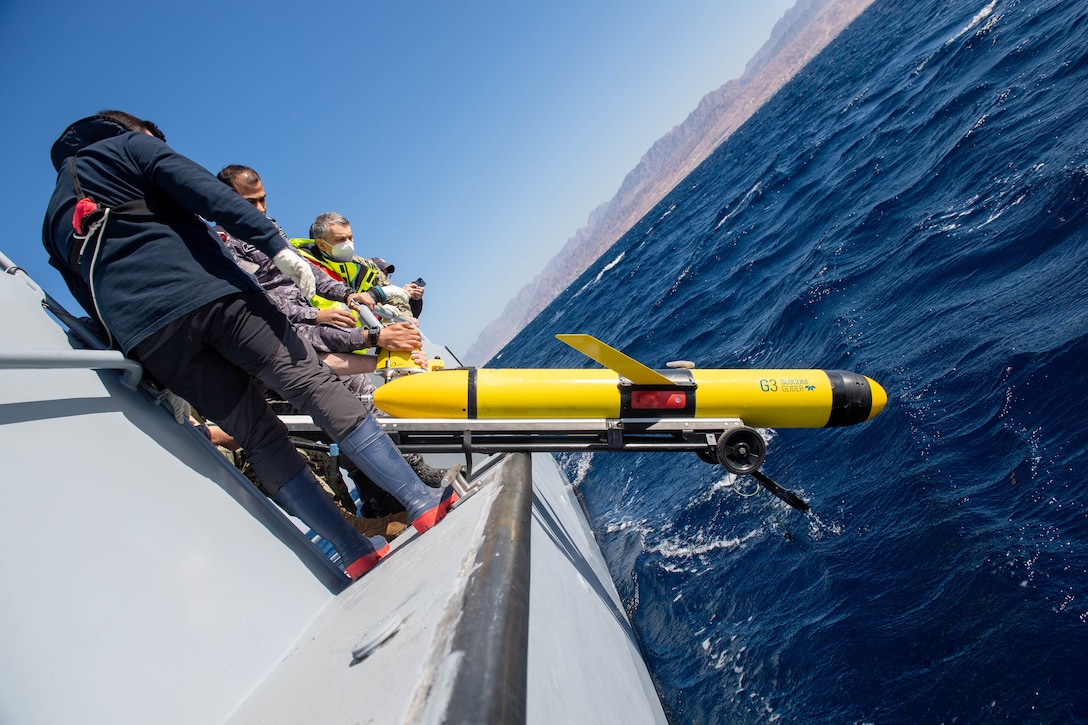 GULF OF AQABA (Feb. 8, 2022) Lt. Donal Hanlon assigned to NATO Center for Maritime Research and Experimentation and members of the Royal Jordanian Navy lower a Slocum Glider unmanned undersea vehicle into the Gulf of Aqaba during International Maritime Exercise/Cutlass Express 2022 Feb. 8. IMX/Cutlass Express 2022 is the largest multinational training event in the Middle East, involving more than 60 nations and international organizations committed to enhancing partnerships and interoperability to strengthen maritime security and stability. (U.S. Navy photo by Mass Communication Specialist 2nd Class Dawson Roth)