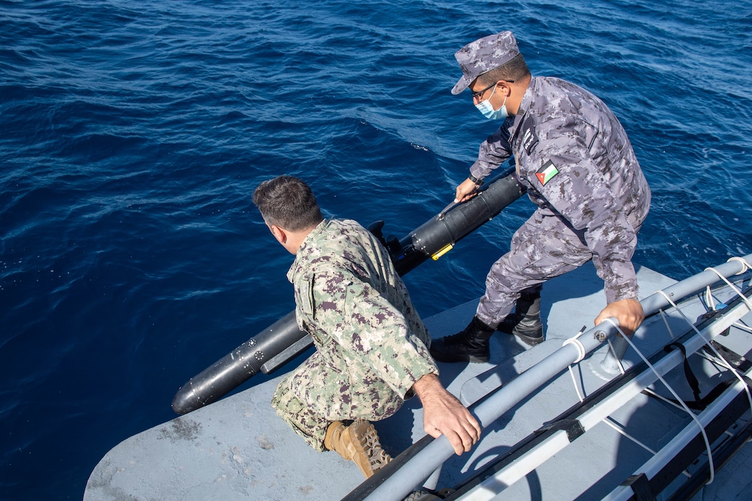 GULF OF AQABA (Feb. 8, 2022) Chief Aerographer's Mate Shawn Mulholland, assigned to Task Force 59, and a member of the Royal Jordanian Navy lower an Iver unmanned undersea vehicle into the Gulf of Aqaba during International Maritime Exercise/Cutlass Express 2022 Feb. 8. IMX/Cutlass Express 2022 is the largest multinational training event in the Middle East, involving more than 60 nations and international organizations committed to enhancing partnerships and interoperability to strengthen maritime security and stability. (U.S. Navy photo by Mass Communication Specialist 2nd Class Dawson Roth)
