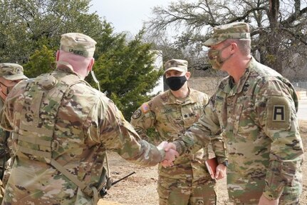 U.S. Army Brig. Gen. Joseph A. Edwards, right, commanding general of First Army Division West, accommodated by Lt. Col. Matthew C. Lewis, center, battalion commander of the 2nd Battalion, 224th Aviation Regiment, 29th Expeditionary Combat Aviation Brigade, Virginia Army National Guard, is greeted by Lt. Col. Curtis J. Unger, observer, controller/trainer and battalion commander of 3rd Battalion, 351st Aviation Regiment, 166th Aviation Brigade, during 2-224th Aviation Regiment’s mobilization for the Kosovo Force mission held at North Fort Hood, Texas, Jan. 25, 2022.