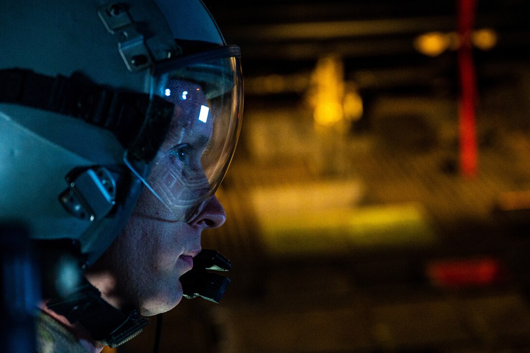 An airman wearing goggles looks to the right.