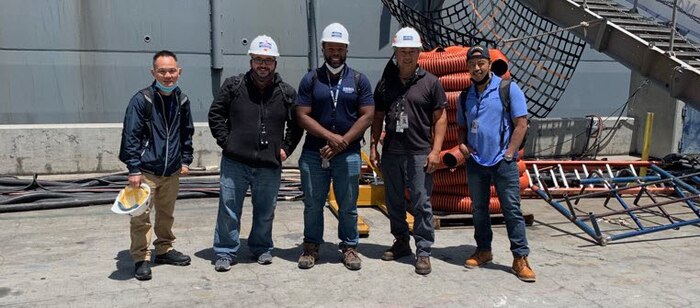 IMAGE: Daquan Styles (center) was recently awarded the Black Engineer of the Year Award for “Most Promising Engineer in Government.” Styles, an electrical engineer in Naval Surface Warfare Center Dahlgren Division Dam Neck Activity’s Combat Readiness Systems Division, was recognized for his work installing complex combat system computer programs aboard aircraft carriers and amphibious ships throughout the COVID-19 pandemic.