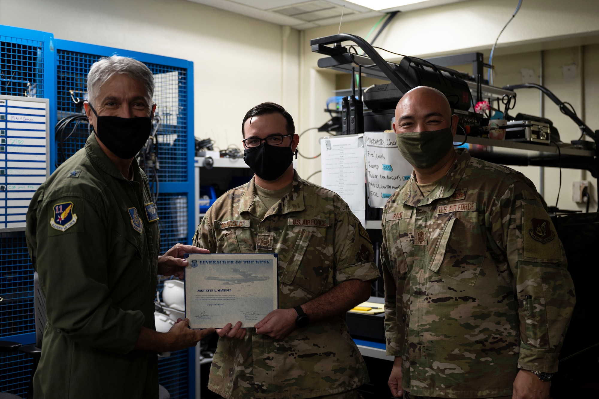 U.S. Air Force Staff Sgt. Kyle Mangold, the non-commissioned officer in charge of radio operations with the 36th Communications Squadron, receives the Linebacker of the Week award from U.S. Air Force U.S. Air Force Brig. Gen. Jeremy Sloane, 36th Wing commander, and Chief Master Sgt. John Payne, 36th Wing command chief, at Andersen Air Force Base, Guam, Feb. 3, 2022.