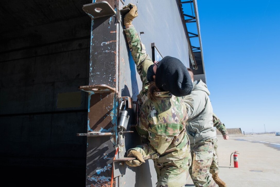 Senior Airman Stephanie Smith, 28th Munitions Squadron line delivery technician, closes a storage facility door at Ellsworth Air Force Base, S.D., Feb. 4, 2022.