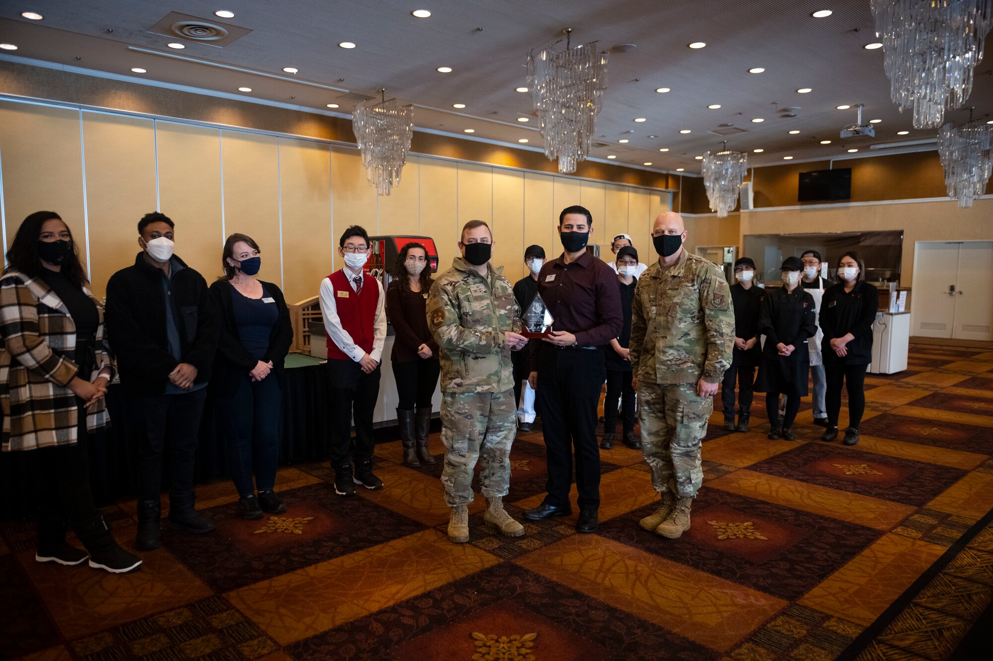 Group of military members in uniform present an award.