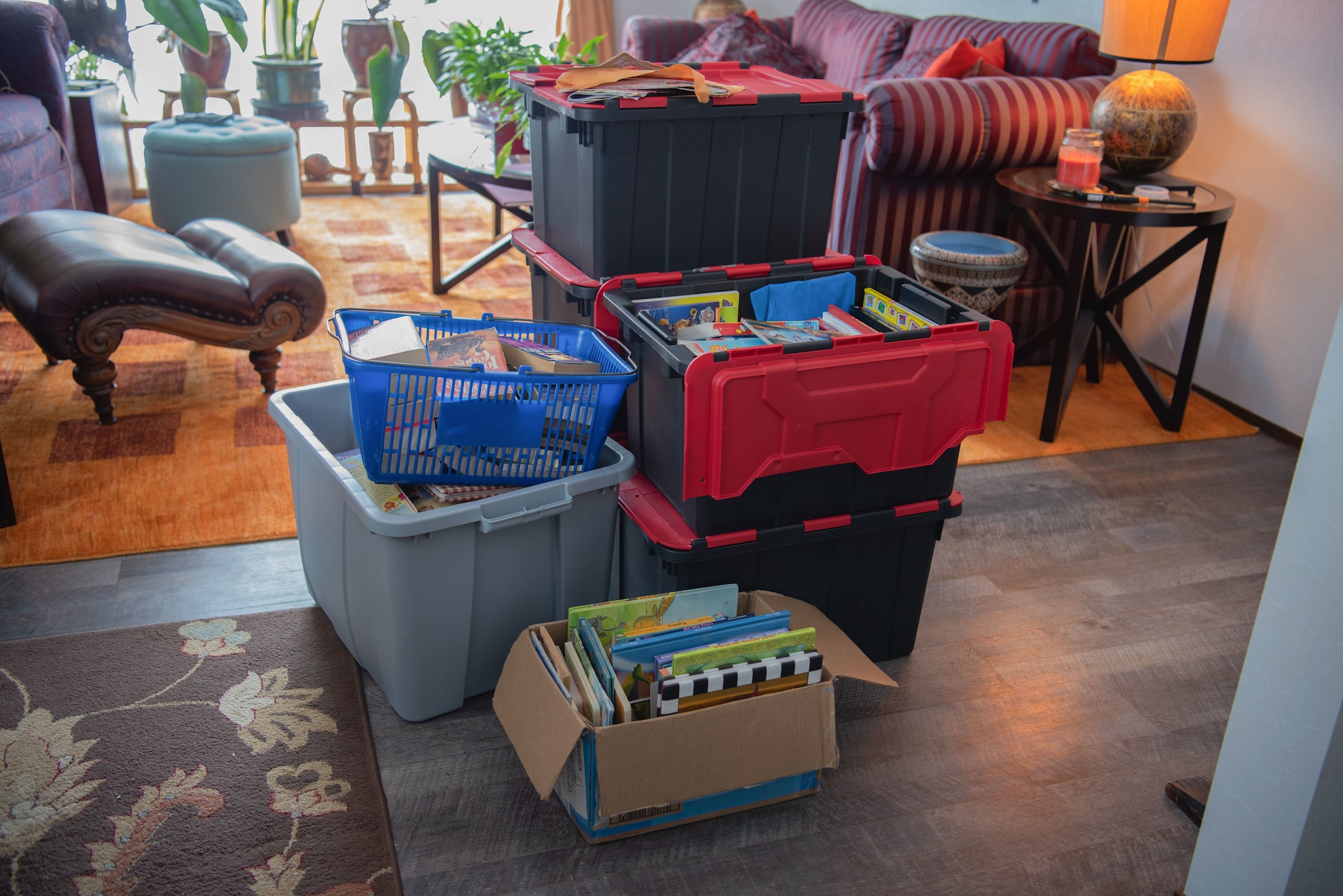 Boxes upon boxes filled with books are stacked inside a home.