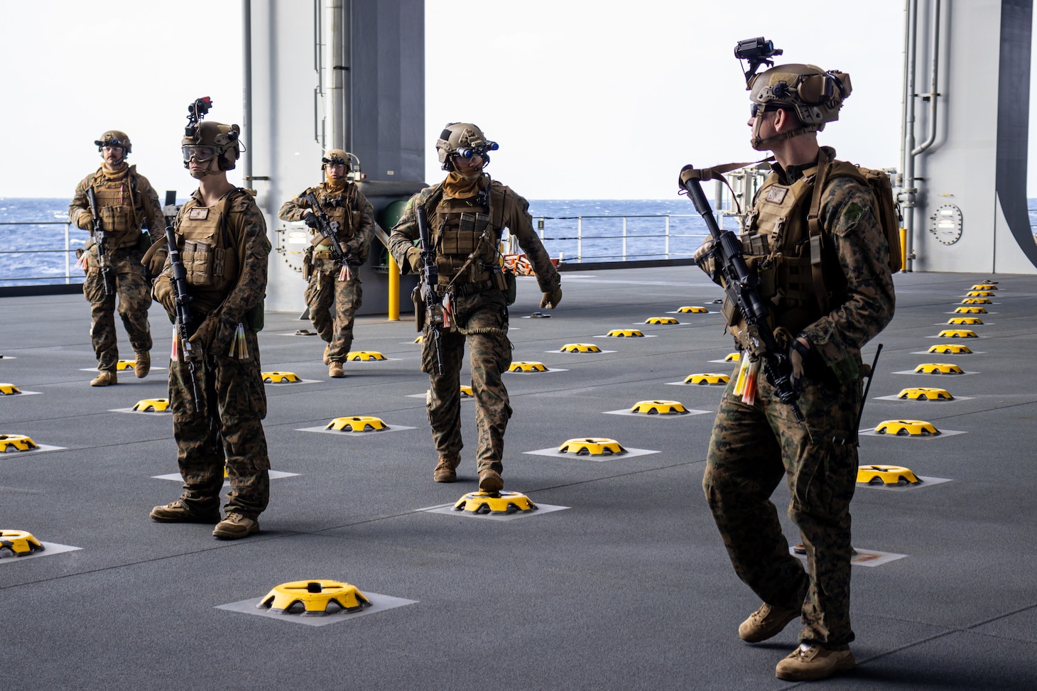 PHILIPPINE SEA (Feb. 5, 2022) U.S. Marines with Maritime Raid Force, 31st Marine Expeditionary Unit (MEU), conduct a patrol through the cargo bay aboard the USS Miguel Keith (ESB 5) during a Visit, Board, Search, and Seizure (VBSS) during operation Noble Fusion in the Philippine Sea, Feb. 5, 2022. VBSS training reinforces the Marine Corps’ presence within ocean waters by having a team at the ready to act in a moment’s notice. Noble Fusion demonstrates that Navy and Marine Corps forward-deployed stand-in naval expeditionary forces can rapidly aggregate Marine Expeditionary Unit/Amphibious Ready Group teams at sea, along with a carrier strike group, joint forces and allies in order to conduct lethal sea-denial operations, seize key maritime terrain, guarantee freedom of movement, and create advantage for US, partner and allied forces. Naval Expeditionary forces conduct training throughout the year, in the Indo-Pacific, to maintain readiness. (U.S. Marine Corps photo by Lance Cpl. Cesar Ronaldo Alarcon)