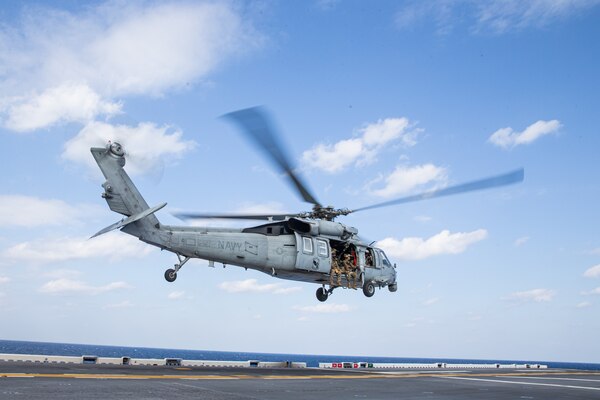 PHILIPPINE SEA (Feb. 5, 2022) U.S. Marines with Maritime Raid Force, 31st Marine Expeditionary Unit (MEU), takeoff in a U.S. Navy MH-60S Sea Hawk helicopter aboard the amphibious assault ship USS America (LHA 6) prior to a Visitation, Board, Search, and Seizure (VBSS) during operation Noble Fusion in the Philippine Sea, Feb. 5, 2022. VBSS training reinforces the Marine Corps’ presence within ocean waters by having a team at the ready to act in a moment’s notice. Noble Fusion demonstrates that Navy and Marine Corps forward-deployed stand-in naval expeditionary forces can rapidly aggregate Marine Expeditionary Unit/Amphibious Ready Group teams at sea, along with a carrier strike group, joint forces and allies in order to conduct lethal sea-denial operations, seize key maritime terrain, guarantee freedom of movement, and create advantage for US, partner and allied forces. Naval Expeditionary forces conduct training throughout the year, in the Indo-Pacific, to maintain readiness. (U.S. Marine Corps photo by Lance Cpl. Malik Lewis)