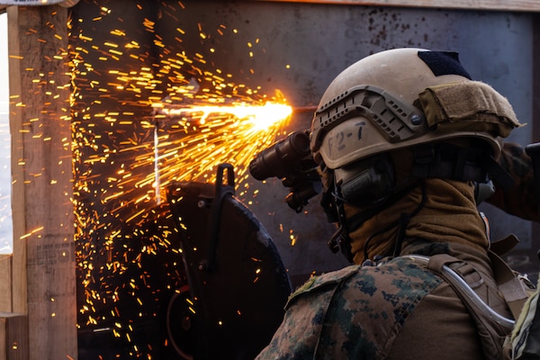 A U.S. Marine with Maritime Raid Force, 31st Marine Expeditionary Unit (MEU), cuts into a makeshift wall using a power saw aboard the USS Miguel Keith (ESB 5) to begin a Visit, Board, Search, and Seizure (VBSS) during operation Noble Fusion in the Philippine Sea, Feb. 5, 2022. VBSS training reinforces the Marine Corps’ presence within ocean waters by having a team at the ready to act in a moment’s notice. Noble Fusion demonstrates that Navy and Marine Corps forward-deployed stand-in naval expeditionary forces can rapidly aggregate Marine Expeditionary Unit/Amphibious Ready Group teams at sea, along with a carrier strike group, joint forces and allies in order to conduct lethal sea-denial operations, seize key maritime terrain, guarantee freedom of movement, and create advantage for US, partner and allied forces. Naval Expeditionary forces conduct training throughout the year, in the Indo-Pacific, to maintain readiness. (U.S. Marine Corps photo by Lance Cpl. Cesar Ronaldo Alarcon)