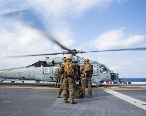 PHILIPPINE SEA (Feb. 5, 2022) U.S. Marines with Maritime Raid Force, 31st Marine Expeditionary Unit (MEU), board a U.S. Navy MH-60S Sea Hawk helicopter aboard the amphibious assault ship USS America (LHA 6) prior to a Visitation, Board, Search, and Seizure (VBSS) during operation Noble Fusion in the Philippine Sea, Feb. 5, 2022. VBSS training reinforces the Marine Corps’ presence within ocean waters by having a team at the ready to act in a moment’s notice. Noble Fusion demonstrates that Navy and Marine Corps forward-deployed stand-in naval expeditionary forces can rapidly aggregate Marine Expeditionary Unit/Amphibious Ready Group teams at sea, along with a carrier strike group, joint forces and allies in order to conduct lethal sea-denial operations, seize key maritime terrain, guarantee freedom of movement, and create advantage for US, partner and allied forces. Naval Expeditionary forces conduct training throughout the year, in the Indo-Pacific, to maintain readiness. (U.S. Marine Corps photo by Lance Cpl. Malik Lewis)