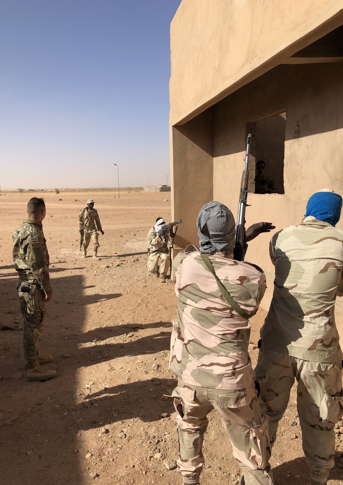 Nigerien Armed Forces (French language: Forces Armées Nigeriennes) members, practice close-quarters battle techniques taught by the 409th Expeditionary Security Forces Squadron air advisors at Nigerien Air Base 201, Agadez, Niger, Feb. 3, 2022. The 409th ESFS hosted an eight-week course to train the FAN on various tactics such as combat lifesaving skills, weapon maneuvers, vehicle searches and patrol movements to counter the escalating violent extremism in the tri-border region of Niger, Burkina Faso, and Mali. (U.S. Air Force courtesy photo by Capt. Keith Richards)
