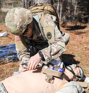 The Louisiana National Guard's Spc. Kevin Sun, a medic with the Louisiana Medical Detachment, applies a dressing to a chest wound during a trauma lane exercise at Camp Beauregard in Pineville, La. on Jan. 29, 2022.