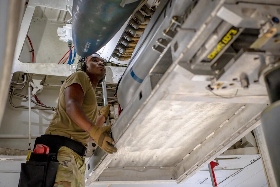 Senior Airman Michael Carradine, 28th Maintenance Group load crew member, guides an AGM-158 Joint Air-to-Surface Standoff Missile into a simulated B-1B Lancer on Ellsworth Air Force Base, S.D., Jan. 28, 2022.