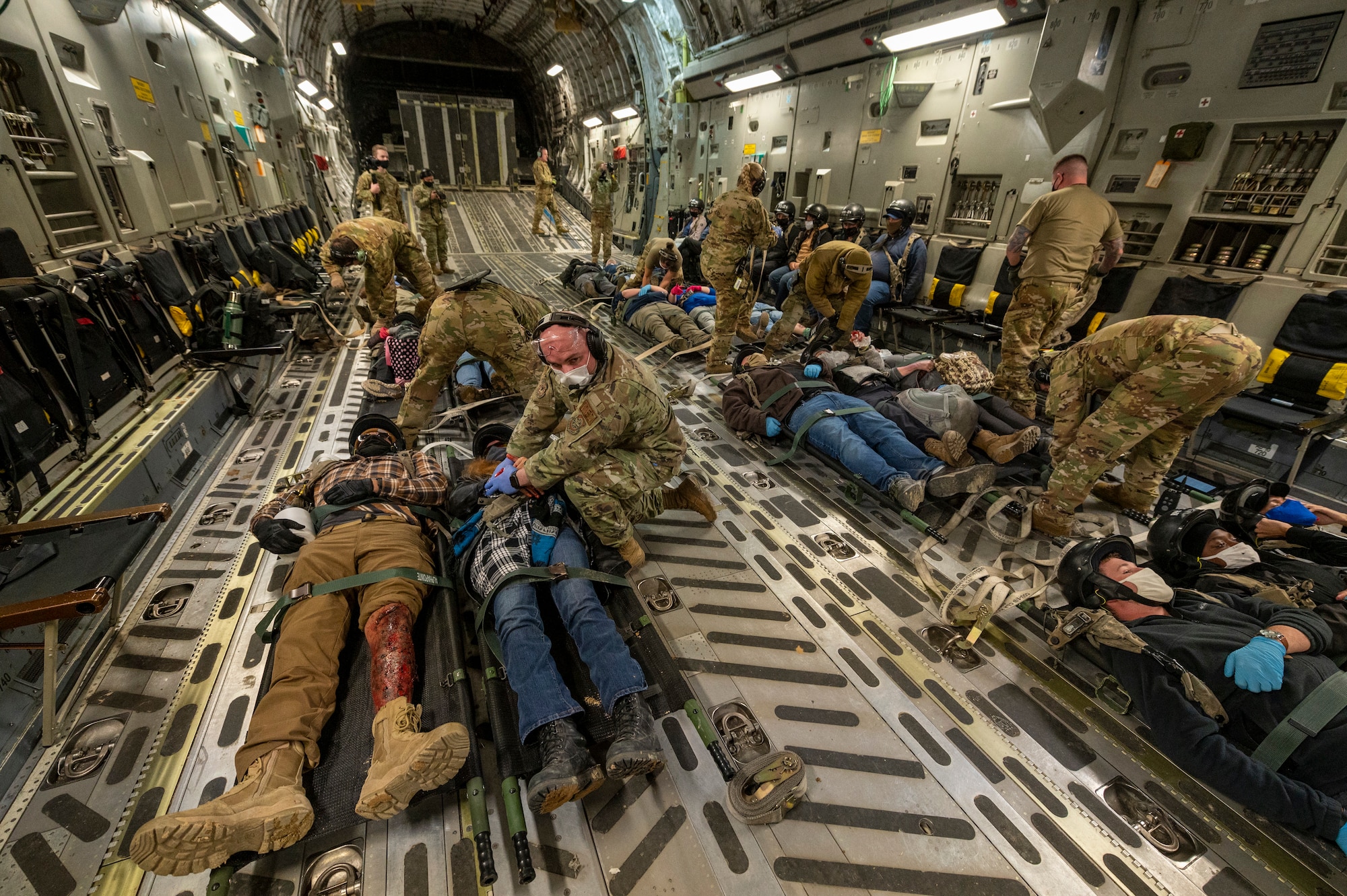 U.S. Air Force aeromedical evacuation specialists secure patients on the floor of a 167th Airlift Wing C-17 Globemaster III aircraft during exercise Green Flag Little Rock 22-03 at Ft. Polk, Louisiana, Jan. 13, 2022. GFLR 22-03 focused on three joint-accredited items: combat airlift; survival, evasion, resistance and escape; and aeromedical evacuation.