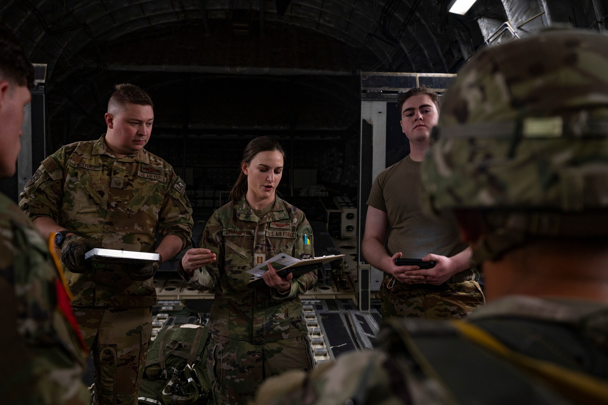U.S. Air Force Capt. Carol Champion, center, a pilot with the 16th Airlift Squadron, briefs U.S. Army jumpmasters assigned to the 82nd Airborne Division, Fort Bragg, North Carolina, during Battalion Mass Tactical Week at Pope Army Airfield, North Carolina, Feb. 4, 2022. BMTW is a joint exercise between the U.S. Air Force and the U.S. Army, which gives participants the ability to practice contingency operations in a controlled environment. (U.S. Air Force photo by Airman 1st Class Charles Casner)