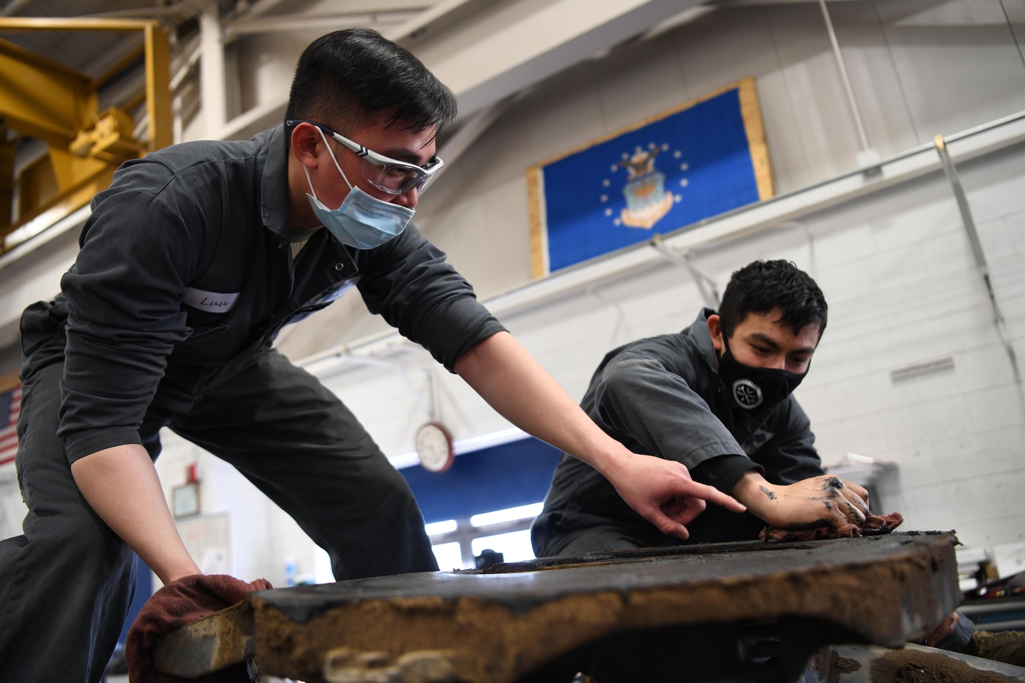 Airman 1st Class An Luu, vehicle mechanic (left), and Airman 1st Class Indigo Schultz, mission generation vehicular equipment maintenance technician, both at the 90th Logistics Squadron, work on a Payload Transporter III at the 90 LRS Vehicle Maintenance Flight warehouse on F.E. Warren Air Force Base, Wyoming, Feb. 8, 2022. The PT III provides the ability to load, unload, transport, emplace, or remove and replace Minuteman weapon system aerospace vehicle equipment and supporting equipment in a controlled environment between launch facilities and base. (U.S. Air Force photo by Airman 1st Class Charles Munoz)